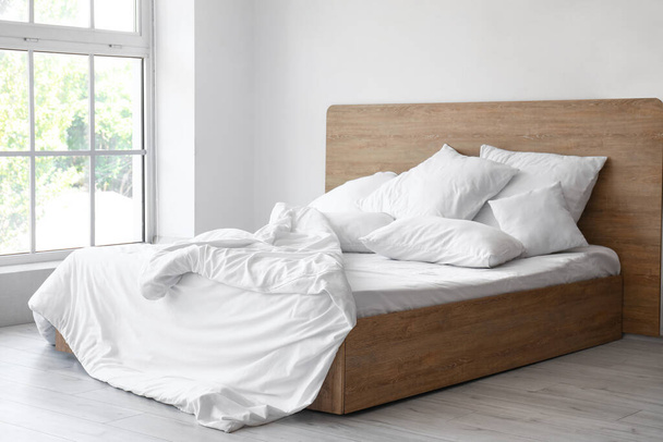 Interior del dormitorio luminoso con cómoda cama doble y almohadas blancas - Foto, Imagen