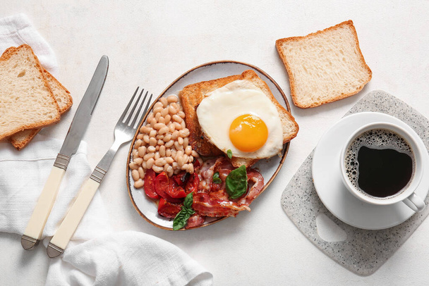 Тарелка с вкусным английским завтраком и чашкой кофе на светлом фоне - Фото, изображение