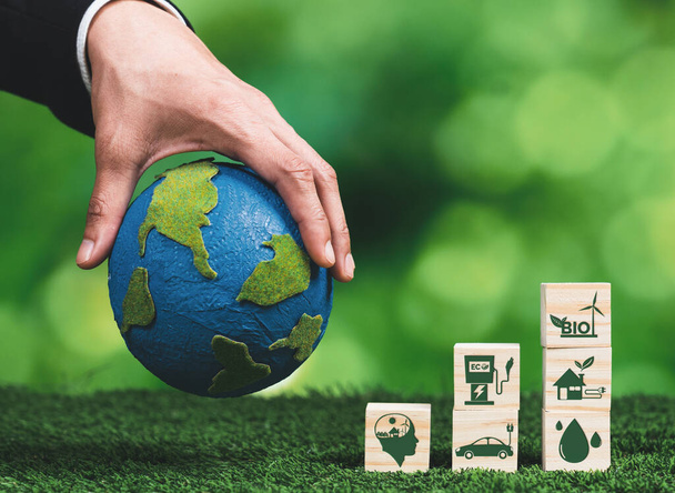 Hand eines Geschäftsmannes, der die Erde in der Hand hält, symbolisiert ein grünes Unternehmen, das Biokraftstofftechnologie und Umweltschutz für nachhaltige, umweltfreundliche Energie für eine saubere Zukunft nutzt. Alter - Foto, Bild