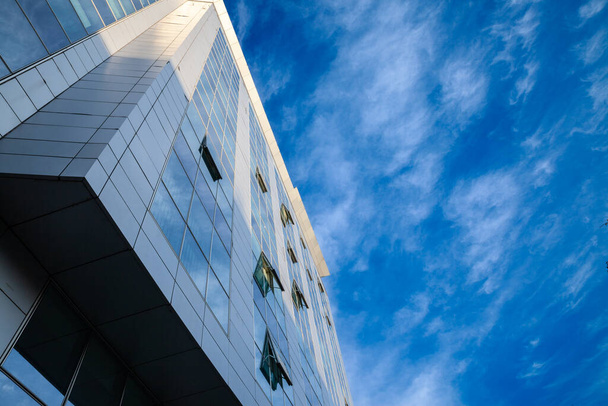 abstrakti julkisivu modernin nykyaikaisen talouden liiketoiminnan rakennus peili ikkunat, jotkut niistä avataan päästää ilmaa toimistossa aurinkoinen sininen taivas taustalla. - Valokuva, kuva
