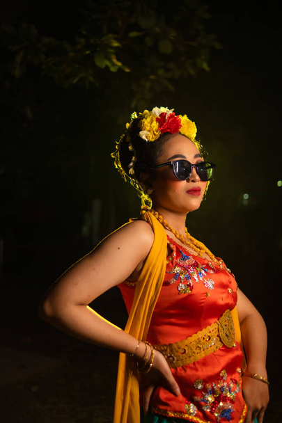 un danseur javanais traditionnel se tient debout et danse avec un corps souple tout en portant des lunettes de soleil la nuit - Photo, image
