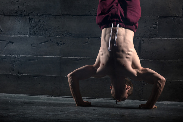 Athlete with naked torso doing push-ups on his hands while stand - Fotografie, Obrázek
