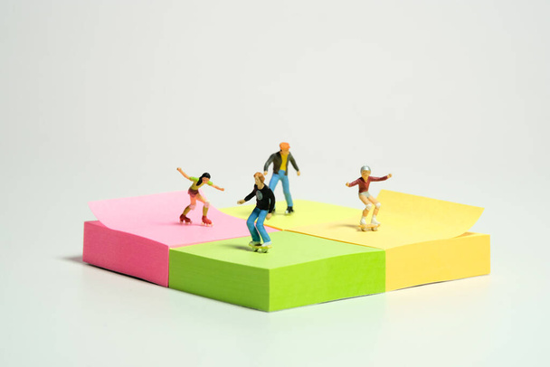 Творческие миниатюрные люди игрушки фигурную фотографию. Установка липких заметок. Дети играют в роллер-скейт-парк. Изолированный на белом фоне. Фото изображения - Фото, изображение