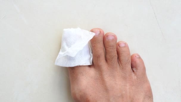 limpiar la herida en los pies de un hombre de un accidente en casa aislado sobre fondo blanco - Metraje, vídeo