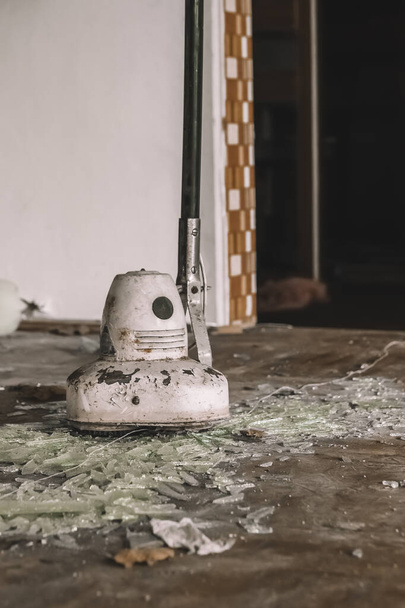 старий брудний полірувальник підлоги в покинутому будинку на розбитому склі - Фото, зображення