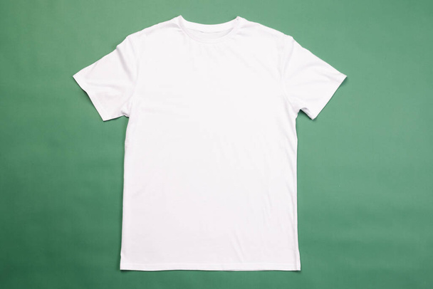White t shirt and copy space on green background. Fashion, clothes, colour and fabric concept. - Fotoğraf, Görsel