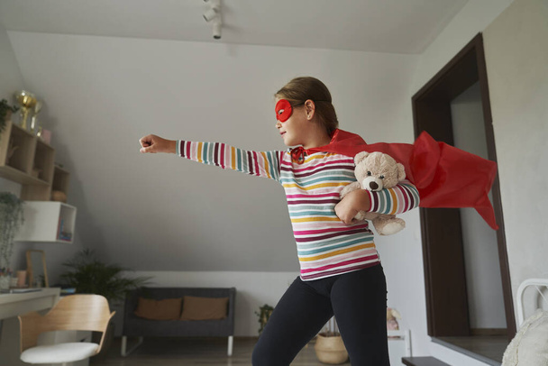 Kaukasische Mädchen spielen eine Rolle im Superheldenkostüm  - Foto, Bild