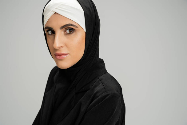 professioneller Kopfschuss einer muslimischen Geschäftsfrau mit Kopfschuss und schwarzer Jacke auf grau - Foto, Bild