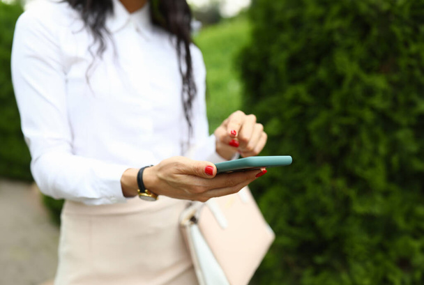 Stílusos nő tart egy okostelefon a kezében, és rámutat a képernyőn az ujjával. App okostelefonok koncepció - Fotó, kép