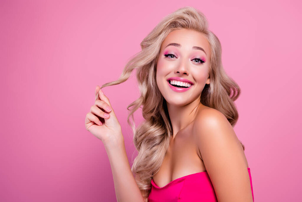 Foto de divertido franco impresionante dama tacto rubio rizo sedoso aplicación de mascarilla de bálsamo para el cabello sobre fondo de color rosa. - Foto, imagen