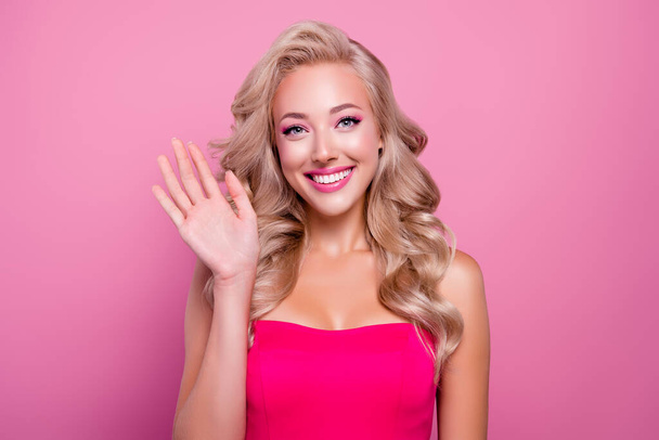 Portrait of pretty girly lady wave hand recording video for barbie fans over pink color background. - Photo, Image