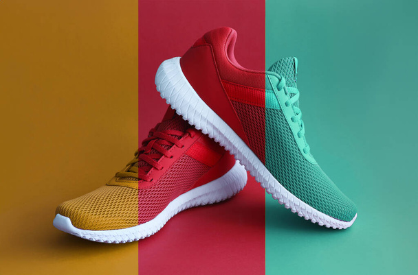 Zapatos deportivos de colores sobre fondo color mostaza. Moda moderna zapatillas de deporte concepto de impresión
 - Foto, Imagen