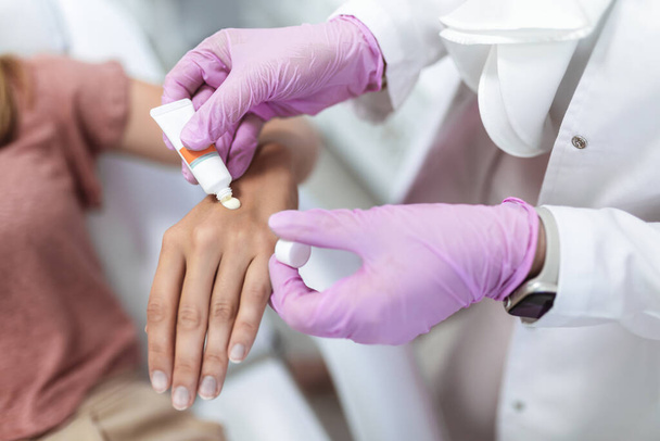 Médecin appliquant la crème protectrice sur les mains du patient - Photo, image