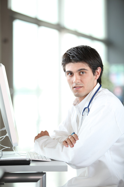 Young doctor working in front of computer - Foto, immagini