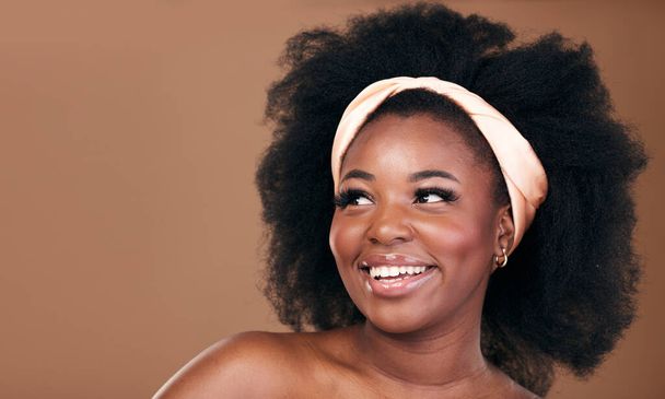 Beauty, hair and idea with a model black woman in studio on a brown background for natural cosmetics. Face, smile and haircare with a happy young afro female person thinking about shampoo treatment. - Photo, Image