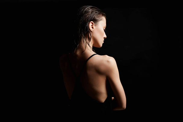 Милая молодая женщина с мокрыми волосами. Красивая сексуальная модель Девушка в черном платье - Фото, изображение