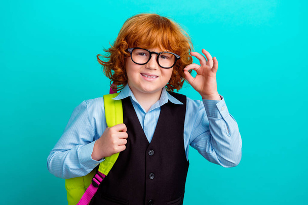 Photo of little positive schoolkid carry rucksack hand fingers demonstrate okey symbol isolated on teal color background. - Foto, Bild