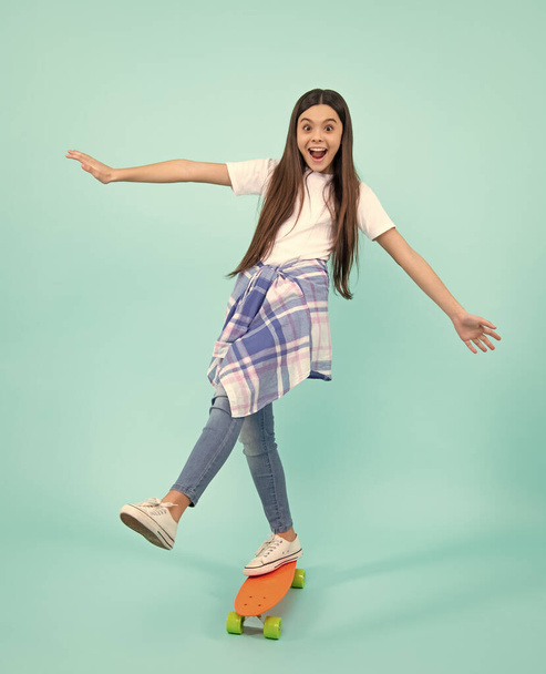 Mode tiener levensstijl, mooie tiener meisje met skateboard geïsoleerd op studio achtergrond. gelukkig tiener, positieve en lachende emoties van tiener meisje - Foto, afbeelding