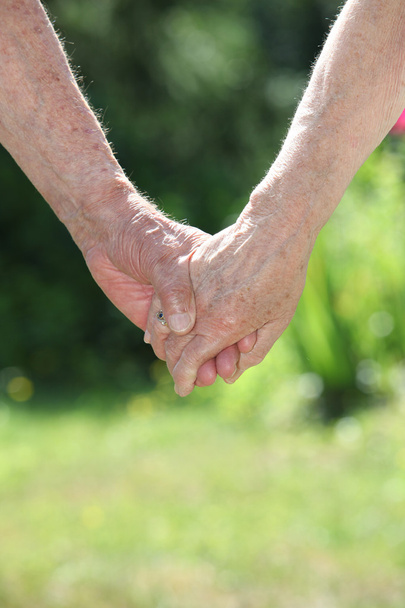 Elderly couple holding hands - Fotó, kép