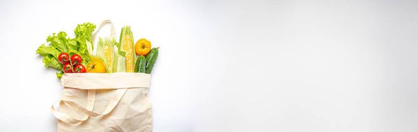 Magasins végétariens. Différents légumes frais dans un sac à provisions textile sur fond blanc, aliments végétaliens sains du supermarché ou concept de livraison, espace de copie. - Photo, image