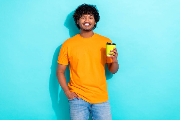 Photo of nice cheerful young man toothy smile hand hold fresh aroma coffee cup isolated on teal color background. - Foto, Imagen