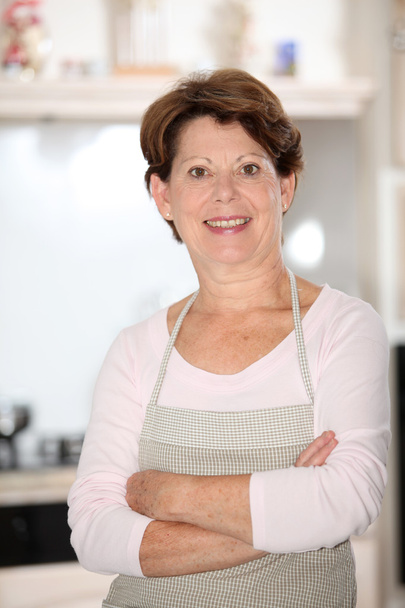 Senior woman standing in kitchen - Fotoğraf, Görsel