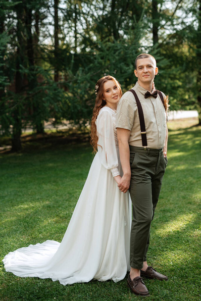 esküvői séta a menyasszony és a vőlegény egy tűlevelű parkban nyáron - Fotó, kép