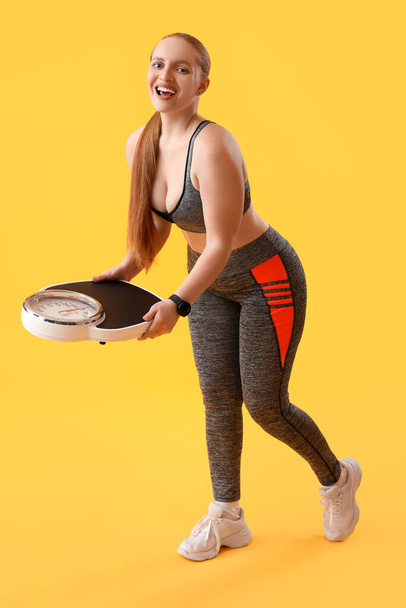 Young overweight woman with scales on yellow background - Photo, Image