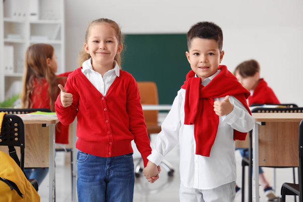 Симпатичні маленькі учні показують великі пальці в класі - Фото, зображення