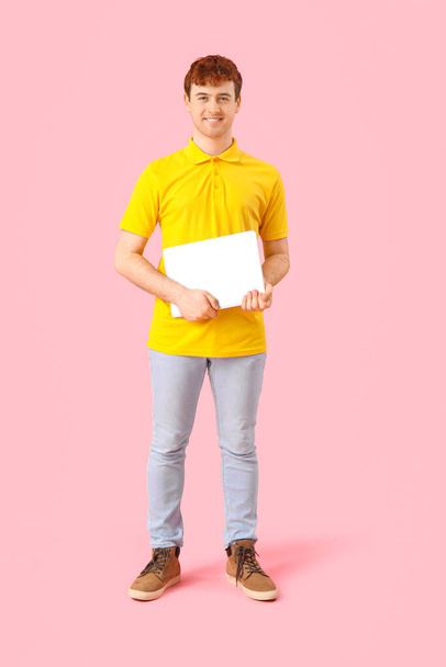 Programmatore maschio con laptop su sfondo rosa - Foto, immagini