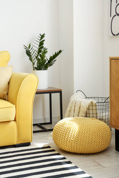 Pouf, cesto con morbida coperta e divano giallo all'interno del soggiorno - Foto, immagini