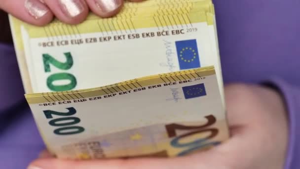 Envase de billetes en euros. Pagos en efectivo en los países de la UE.Paquete de doscientos euros en manos femeninas close-up. - Metraje, vídeo