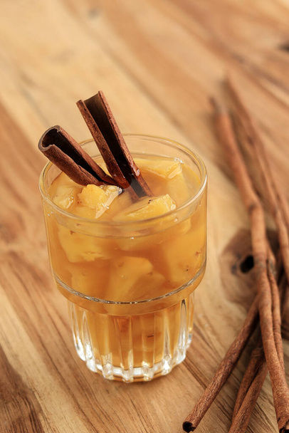 Нанас, индонезийский традиционный напиток из нарезанного спелого ананаса, сахара и корицы. Ананасовое рагу с корицей - Фото, изображение