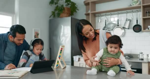 Home school help, parents with child and baby in kitchen, tablet, headphones and support in learning with family. Elearning, studying and father teaching girl with homework for online class project - Video
