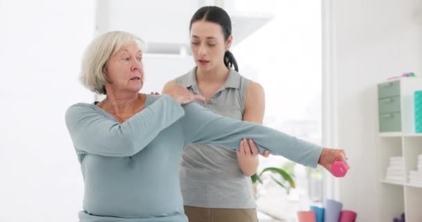 Senior woman, physiotherapy and dumbbell exercise, stretching arm and support in physical therapy exam. Workout, shoulder pain and fitness of elderly person, patient and nurse in medical consultation. - Video, Çekim