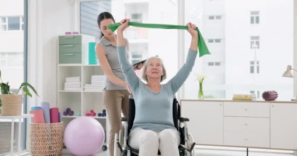 Donna anziana con disabilità, fisioterapista e fascia elastica per riabilitazione muscolare, valutazione sanitaria e servizi di chiropratica. Fisioterapia, guarigione e supporto del paziente sulla sedia a rotelle. - Filmati, video