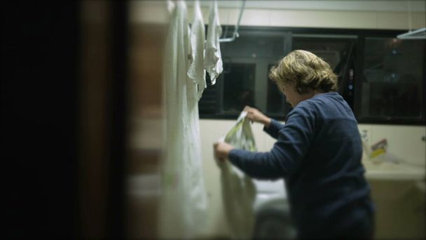 Codzienne domowe obowiązki / Starsza kobieta wisi pranie na suszarce - Zdjęcie, obraz