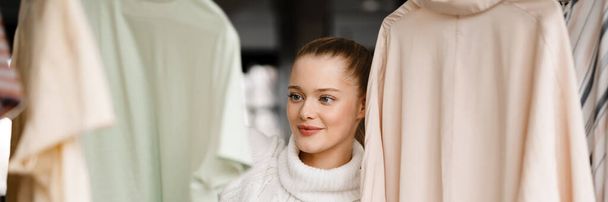 Young smiling blonde white woman choosing clothes at home - Photo, image
