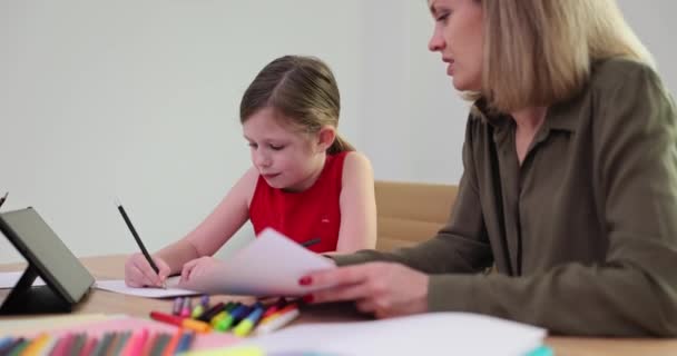 Moeder en dochter schetsen samen het plaatje. volwassen vrouw helpen meisje en leren tekenen - Video
