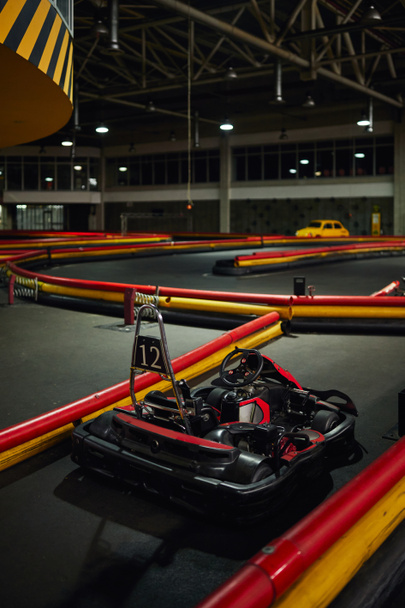 design of racing car inside of indoor kart circuit, red motor race vehicle with number twelve - Фото, изображение