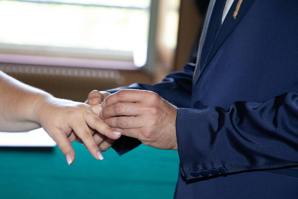 Gelinin alyansları damadın eline takıldı. Evlilik kutlaması için parmaklar havaya. - Fotoğraf, Görsel
