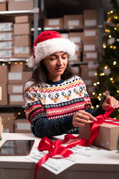 Vrolijk Kerstmis verzending concept. Kerstman verpakking cadeauverpakking geschenk met rood lint voorbereiding van de post verzending pakket. Kopieerruimte - Foto, afbeelding