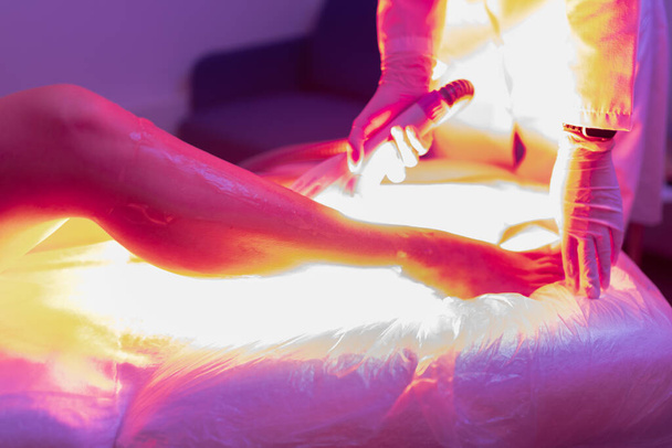 Laser hair removal and cosmetology. Cosmetic hair removal procedure. bright laser flash creative colorful shot. - 写真・画像