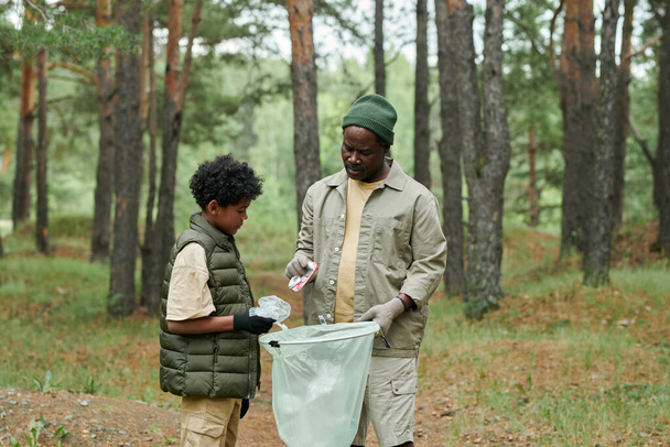 Αφρο-αμερικανική οικογένεια των δύο καθαρισμού του δάσους από σκουπίδια μαζί - Φωτογραφία, εικόνα