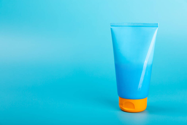 Sunscreen. Jar, cosmetic tube with SPF cream on a bright blue background. The concept of skin care and protection from ultraviolet rays. Photoaging. Sunscreen selection.place for text.copy space. - Photo, Image