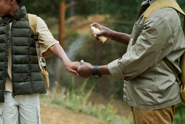 Papà protegge suo figlio dagli insetti usando lo spray durante le loro escursioni nella foresta - Foto, immagini