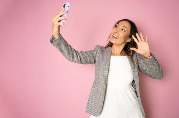 Geschäftsfrau macht Selfie mit großem Smartphone. isoliertes Frauenporträt. - Foto, Bild