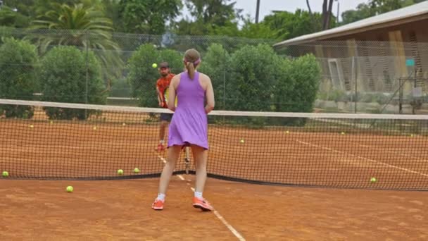 Felnőtt férfi és nő teniszeznek a szabadtéri pályán. Középső felvétel - Felvétel, videó
