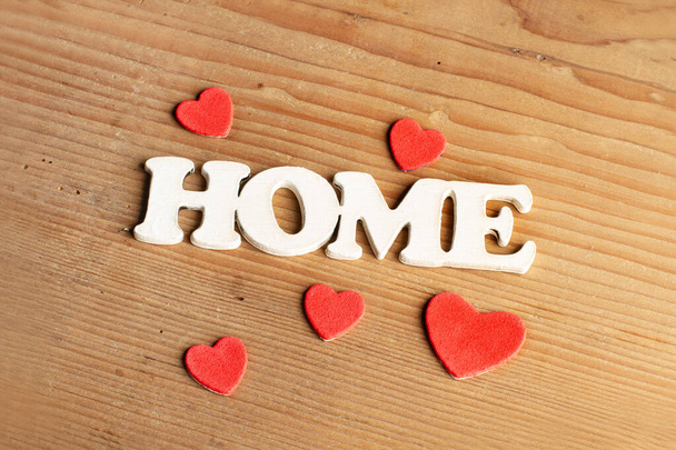 Um sinal de casa com corações vermelhos em um fundo de madeira com espaço de cópia - Foto, Imagem