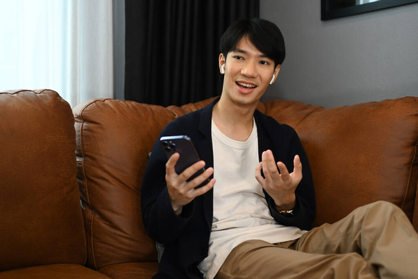 asiatico uomo parlando con cellulare in soggiorno.. - Foto, immagini